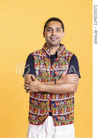 Portrait of radiant calm indian man smiling, looking pleased, isolated over studio background. Joyous expressive asian person in traditional clothing grinning, feeling satisfied 124833071