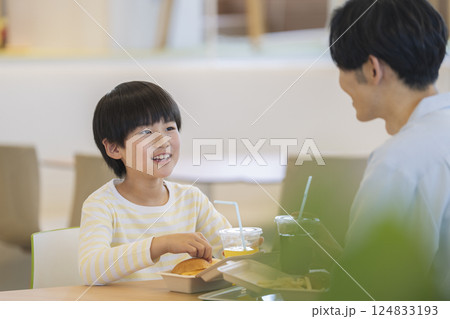 ハンバーガーを食べる親子 笑顔の9歳の男の子 ハンバーガーを食べる親子 笑顔の9歳の男の子 124833193