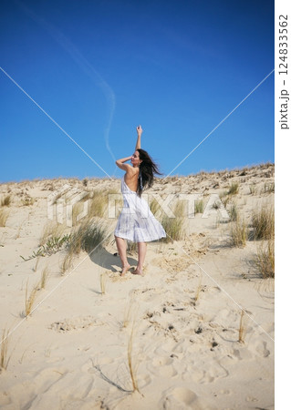 Summer fashion shoot on sand dunes with clear sky and wild beach style Summer fashion shoot on sand dunes with clear sky and wild beach style 124833562