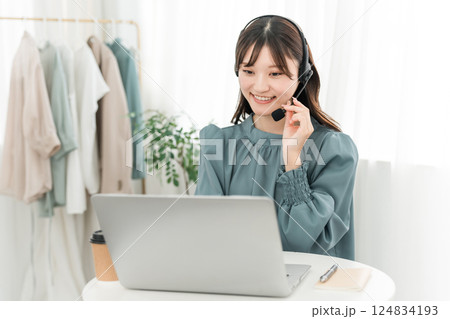 ヘッドセットをつけてパソコンを使う女性 ヘッドセットをつけてパソコンを使う女性 124834193