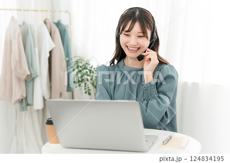 ヘッドセットをつけてパソコンを使う女性 ヘッドセットをつけてパソコンを使う女性 124834195