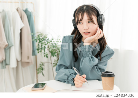ヘッドホンで音楽を聴くアジア人女性 ヘッドホンで音楽を聴くアジア人女性 124834336