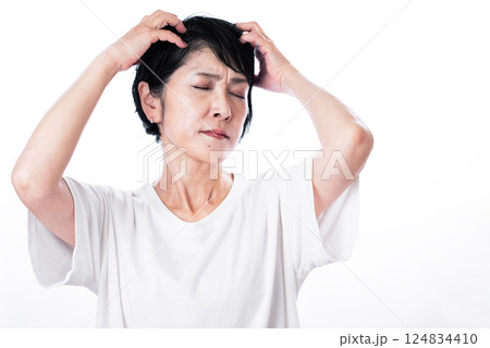 頭皮マッサージで苦悩の表情をする中年女性 124834410