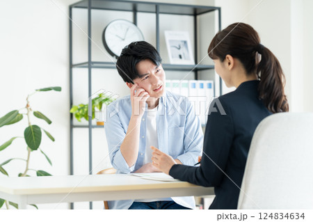 プランナーに相談する若い男性 プランナーに相談する若い男性 124834634