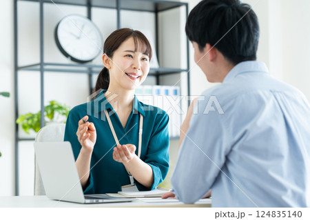 若い男性に説明するプランナーの女性 124835140