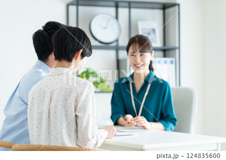 若い夫婦の相談にのるプランナー 124835600