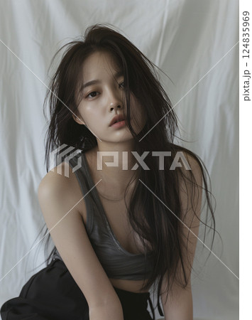 シンプルなタンクトップとデニムパンツを着た自然体のアジア人女性 シンプルなタンクトップとデニムパンツを着た自然体のアジア人女性 124835969