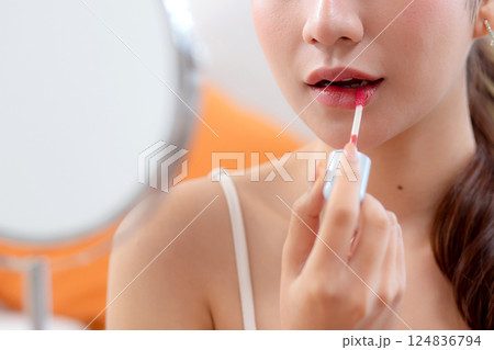 Closeup hands beauty young asian woman applying makeup with lipstick looking mirror. Closeup hands beauty young asian woman applying makeup with lipstick looking mirror. 124836794