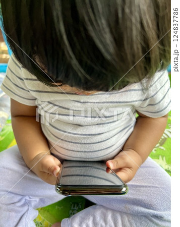 Close up of Asian baby using smart phone in the park at summer. 124837786