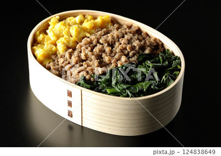 卵、肉、ほうれん草の三色弁当を黒背景で撮影 卵、肉、ほうれん草の三色弁当を黒背景で撮影 124838649