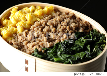 卵、肉、ほうれん草の三色弁当を黒背景で撮影 卵、肉、ほうれん草の三色弁当を黒背景で撮影 124838652