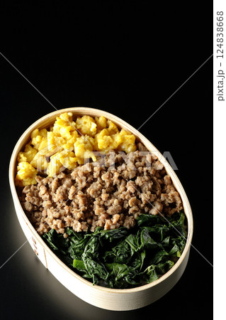 卵、肉、ほうれん草の三色弁当を黒背景で撮影 卵、肉、ほうれん草の三色弁当を黒背景で撮影 124838668