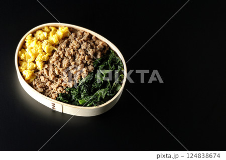 卵、肉、ほうれん草の三色弁当を黒背景で撮影 卵、肉、ほうれん草の三色弁当を黒背景で撮影 124838674