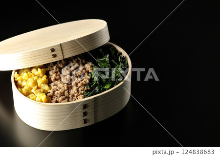卵、肉、ほうれん草の三色弁当を黒背景で撮影 卵、肉、ほうれん草の三色弁当を黒背景で撮影 124838683
