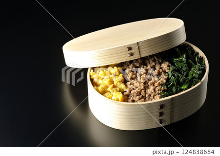 卵、肉、ほうれん草の三色弁当を黒背景で撮影 卵、肉、ほうれん草の三色弁当を黒背景で撮影 124838684