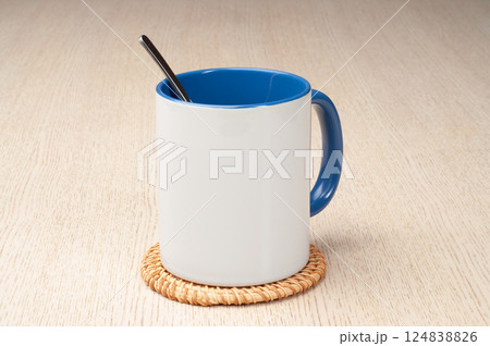 Two-tone 11oz mug on the mug coaster on the table. Mug with spoon, cinnamon, star anise. Mug with green handle and inner part. Two-tone 11oz mug on the mug coaster on the table. Mug with spoon, cinnamon, star anise. Mug with green handle and inner part. 124838826