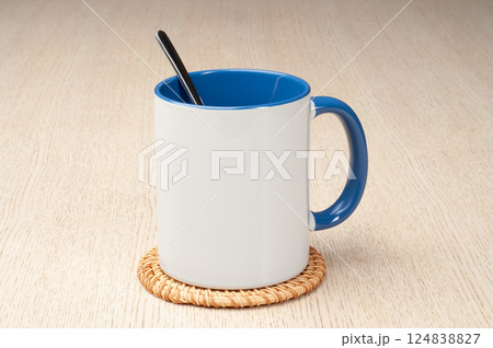 Two-tone 11oz mug on the mug coaster on the table. Mug with spoon, cinnamon, star anise. Mug with green handle and inner part. Two-tone 11oz mug on the mug coaster on the table. Mug with spoon, cinnamon, star anise. Mug with green handle and inner part. 124838827