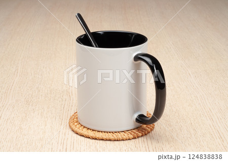 Two-tone 11oz mug on the mug coaster on the table. Mug with spoon, cinnamon, star anise. Mug with green handle and inner part. Two-tone 11oz mug on the mug coaster on the table. Mug with spoon, cinnamon, star anise. Mug with green handle and inner part. 124838838