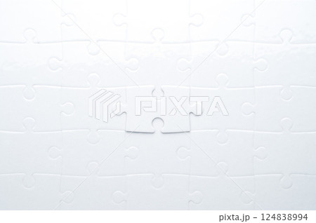 Concept for problem-solving, teamwork, solutions, or missing connections. White jigsaw puzzle on a vibrant blue background with one missing piece. Minimalist composition with copy space. 124838994