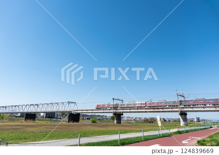 多摩川のサイクリングロードから見た京王線の電車 春の青空 東京都調布市多摩川 多摩川のサイクリングロードから見た京王線の電車 春の青空 東京都調布市多摩川 124839669