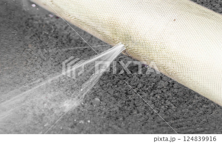 Water leaking from hole in a hose. Water leaking from hole in a hose. 124839916
