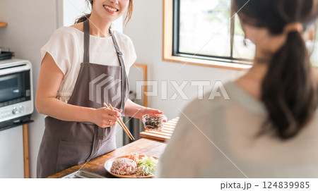 料理教室・クッキングスクールで料理を教える講師の女性と生徒の女性 料理教室・クッキングスクールで料理を教える講師の女性と生徒の女性 124839985