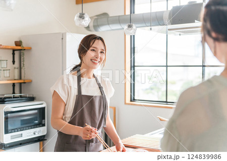 料理教室・クッキングスクールで料理を教える講師の女性と生徒の女性 料理教室・クッキングスクールで料理を教える講師の女性と生徒の女性 124839986