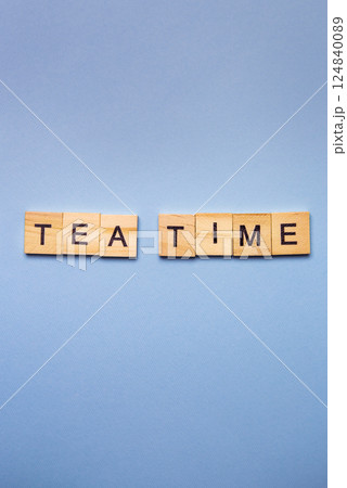 Wooden blocks spell out 'Tea Time' on a light blue background 124840089
