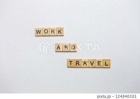Wooden inscription from cubes - work and travel on a white background, top view. 124840101