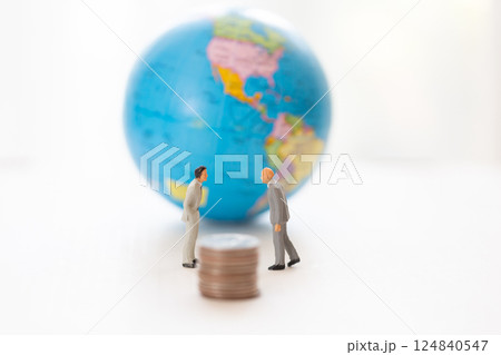 貿易 関税 お金のイメージ 地球儀と向き合うビジネスマンのミニチュア 124840547