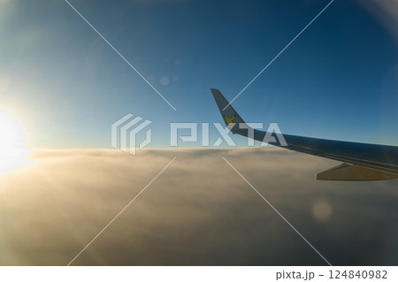 飛行機の窓から見える日の出 124840982