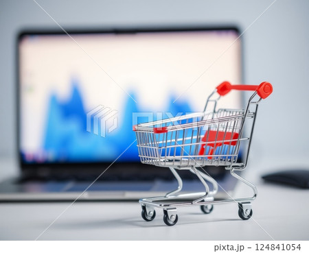 Small cart with computer in the background concept for e-commerce 124841054