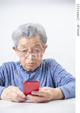 スマホを見るおばあさん 124841121
