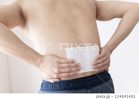 腰に湿布を貼る男性　腰痛　湿布　筋肉痛 124841481
