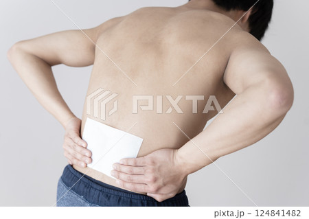 腰に湿布を貼る男性　腰痛　湿布　筋肉痛 124841482