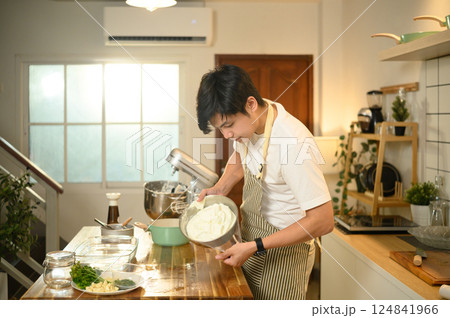 Focused asian man making fresh dessert toppings in a warm kitchen 124841966