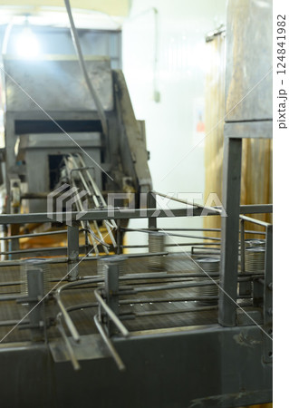 Metal cans move along an industrial conveyor system inside a seafood processing facility Metal cans move along an industrial conveyor system inside a seafood processing facility 124841982