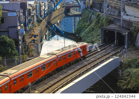 Red Train Passing by Canal in Urban City Neighborhood, Ochanomizu Dec 8 2024 124842344