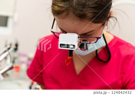 Dedicated dental professional meticulously caring for a patient in a bright clinic during a routine check-up in a modern facility 124842432