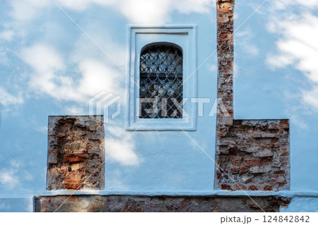 Window with a grille on the wall. 124842842