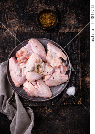 Raw chicken wings on black background. 124843213