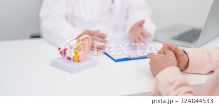 Elderly Patient consulting Doctor to Ear disease. Senior Health Medical Diagnosis. Anatomy Ear model for Atresia, Otitis Media, Pertorated Eardrum, Meniere syndrome, otolaryngologist, Hearing Loss 124844533