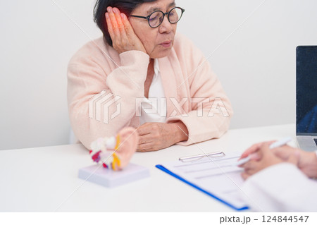 Elderly Patient consulting Doctor to Ear disease. Senior Health Medical Diagnosis. Anatomy Ear model for Atresia, Otitis Media, Pertorated Eardrum, Meniere syndrome, otolaryngologist, Hearing Loss 124844547