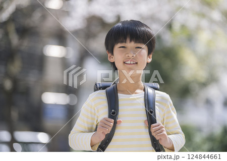 ランドセルを背負ったカメラ目線で笑顔の9歳の男の子 124844661