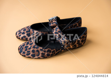 Leopard print textile ballet flats with buckle detail on beige background Leopard print textile ballet flats with buckle detail on beige background 124844814