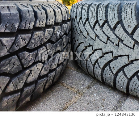 Winter and summer car tires lie on the ground. Seasonal tire change. Winter and summer car tires lie on the ground. Seasonal tire change. 124845130