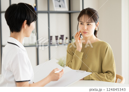 エステサロンのカウンセリングを受ける若い女性 エステサロンのカウンセリングを受ける若い女性 124845343