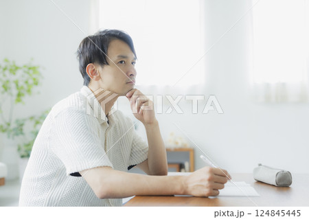 リビングで勉強をする30代男性 リビングで勉強をする30代男性 124845445