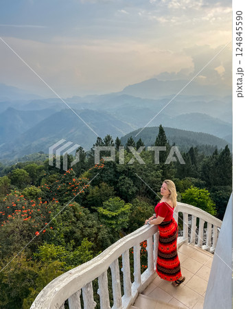 A blonde woman enjoys the view from a tower at the Ambuluwawa Temple A blonde woman enjoys the view from a tower at the Ambuluwawa Temple 124845590