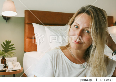 Portrait of beautiful blonde woman in bedroom 124845631